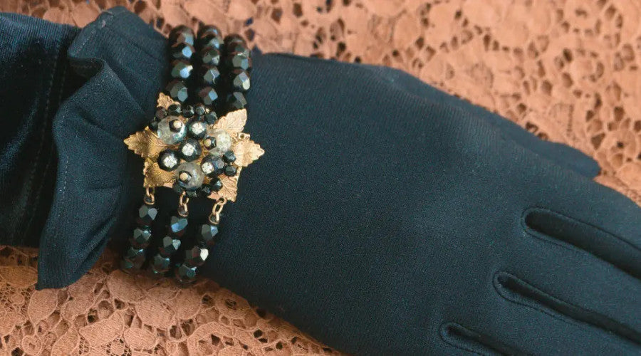 Three row black bead expansion bracelet with gold leaf corsage