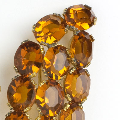 Close-up view of faceted, oval golden-topaz stones oval